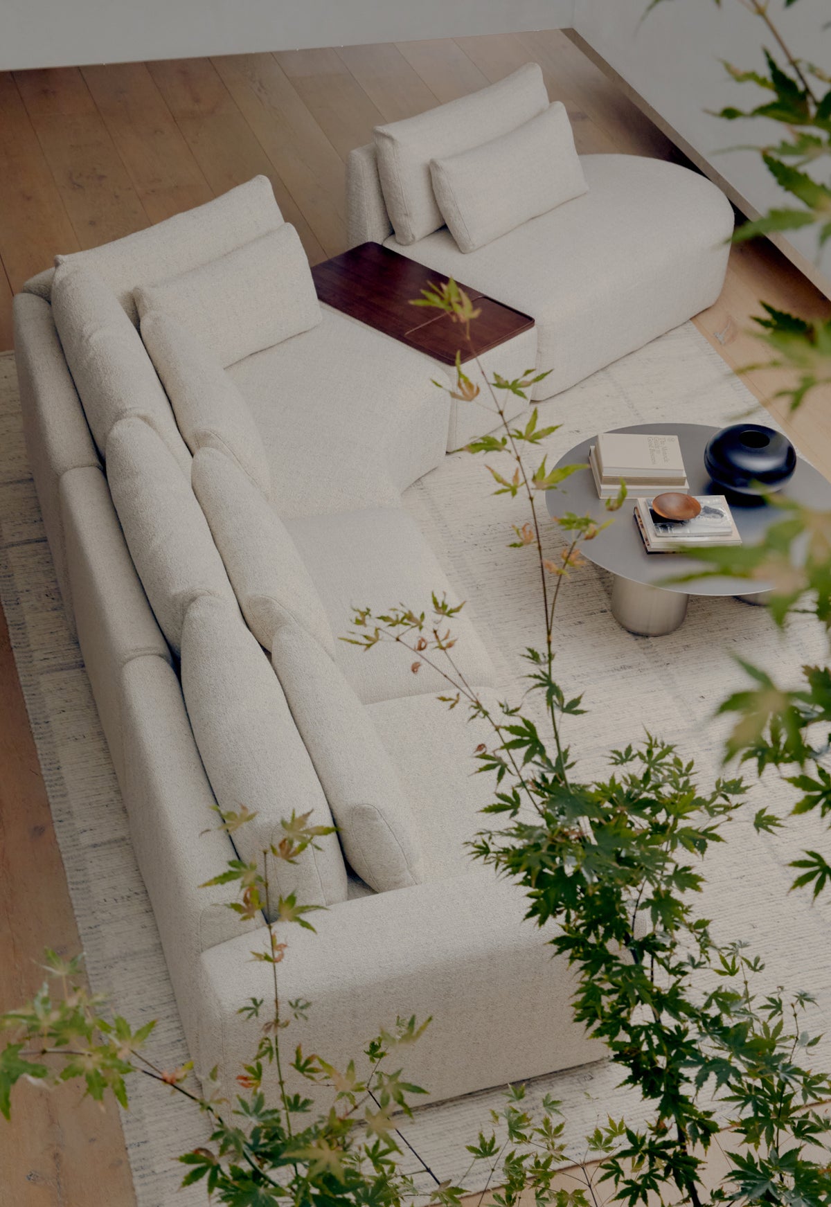 Modern living room with a white modular sofa, coffee table, and decorative items.
