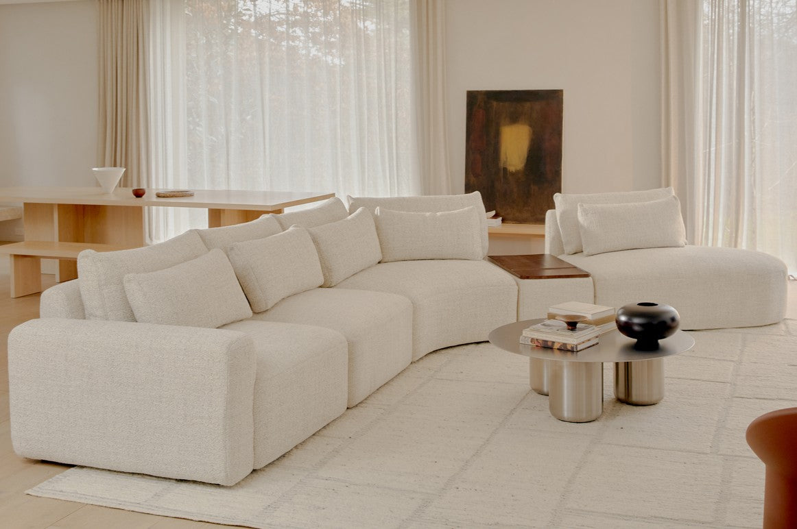 White modular sofa in a modern living room with a coffee table and decorative items.